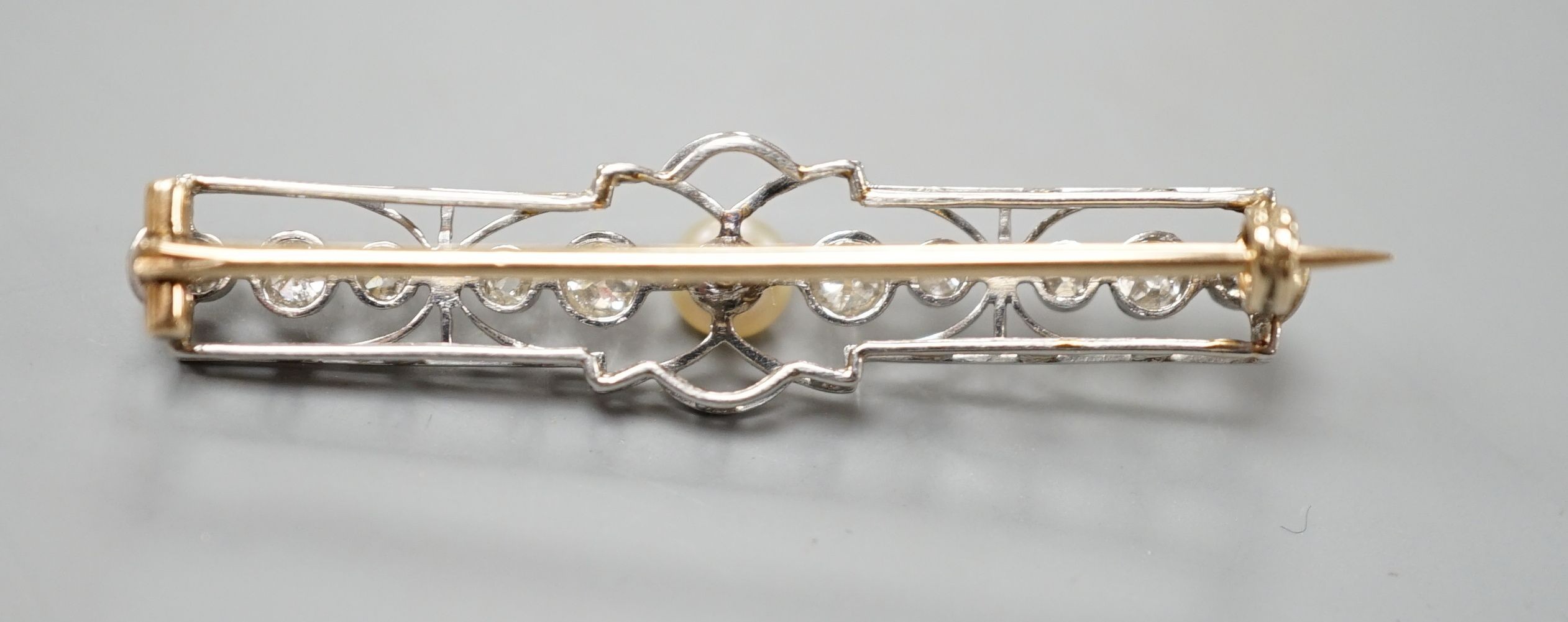An early 20th century, yellow and white meta, cultured pearl and diamond set open work bar brooch, 41mm, gross weight 3.6 grams.